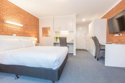 a hotel room with a bed and a kitchen at Mildura City Gate Motel in Mildura