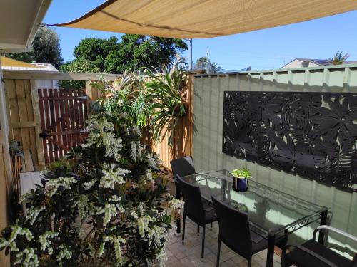 a patio with a table and chairs and a fence at Warilla Sands in Lake Illawarra