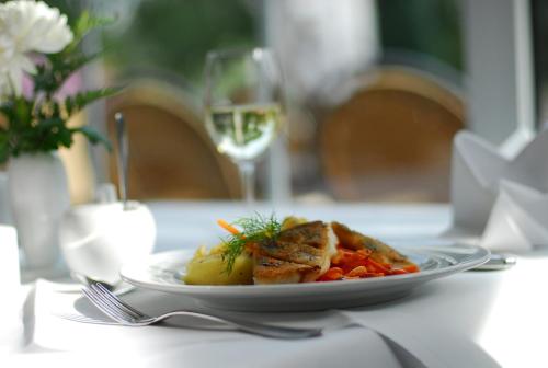 a plate of food on a table with a glass of wine at Spreewaldhotel Stephanshof in Lübben