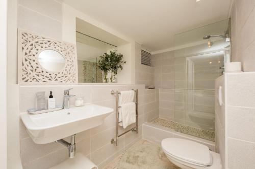 a white bathroom with a sink and a toilet at Wixy in Cape Town