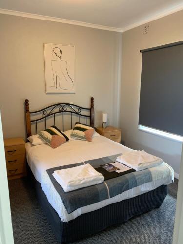 a bedroom with a bed with a large window at Hello Adelaide Motel and Apartments in Adelaide