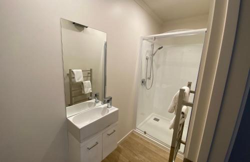 une salle de bain blanche avec un lavabo et un miroir dans l'établissement Ribbonwood Cottage, à Lac Tekapo