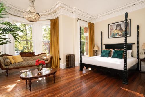 um quarto com uma cama, um sofá e uma mesa em The Harrison Chambers of Distinction em Belfast