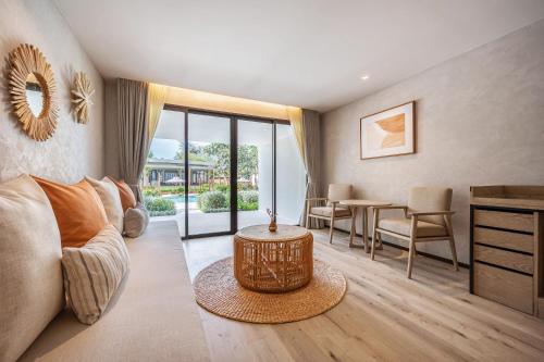 a living room with a couch and a table at VALA Hua Hin - Nu Chapter Hotels in Cha Am