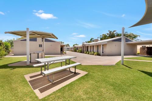 a picnic table in the grass in front of a building at Kennedy Holiday Villas in Mulwala