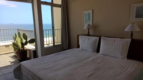 1 dormitorio con 1 cama y vistas al océano en COPACABANA VISTA MAR COBERTURA 2 ANDARES DE FRENTE PARA OS FOGOS DO RÉVEILLON COM 5 QUARTOS, 5 AR-CONDICIONADOS, 6 BANHEIROS e GARAGEM GRATUITA, en Río de Janeiro