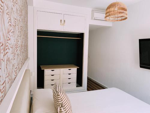 Habitación pequeña con cama y ventana en Boutike Guesthouse, en Sevilla