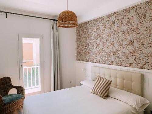 una camera con un letto bianco e una finestra di Boutike Guesthouse a Siviglia