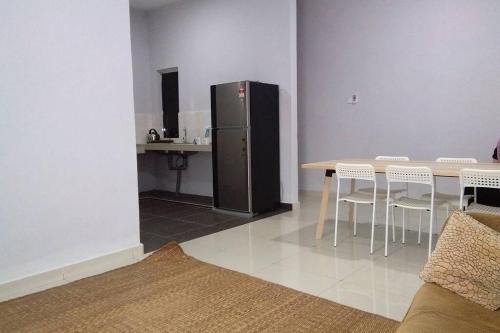 a kitchen with a table and a refrigerator in a room at Meru Homestay suitable for up to 7 people in Klang