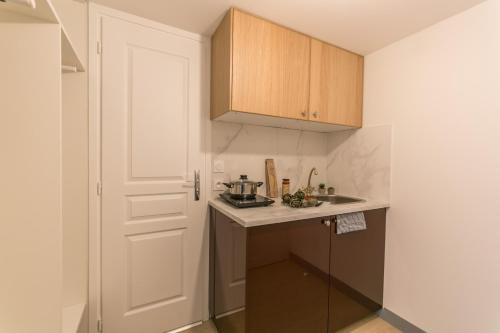 a small kitchen with a sink and a door at WS Tour Eiffel - Nicolo in Paris