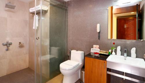 a bathroom with a toilet and a shower and a sink at Spice Grove in Thekkady