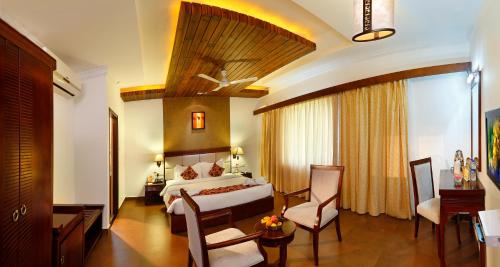 a hotel room with a bed and a desk and chairs at Spice Grove in Thekkady
