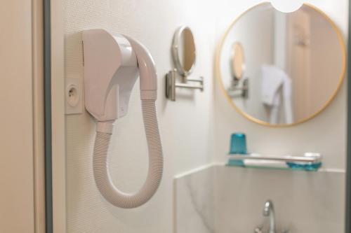 a white phone hanging on a wall in a bathroom at WS Tour Eiffel - Nicolo in Paris