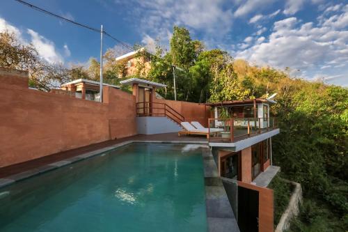 einen Pool mit Terrasse und ein Haus in der Unterkunft Seven Havens Residence in Selong Belanak