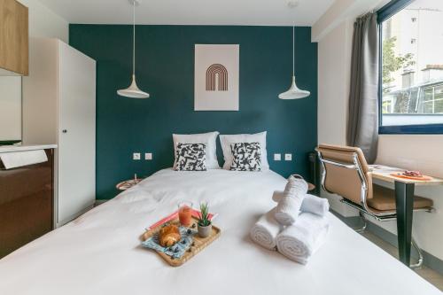 a bedroom with a white bed with a green wall at WS Tour Eiffel - Nicolo in Paris