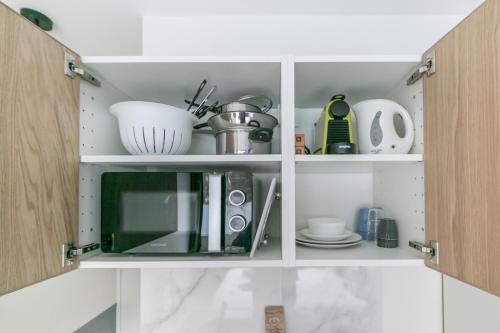 a kitchen cabinet with a microwave and dishes in it at WS Tour Eiffel - Nicolo in Paris