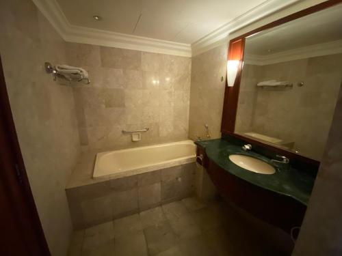 Times Square Kuala Lumpur JN في كوالالمبور: حمام مع حوض استحمام ومغسلة ومرآة