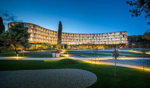 a large building with lights in front of it at Family Hotel Amarin by Maistra Select in Rovinj