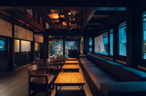 a row of tables in a restaurant with windows at nol kyoto sanjo in Kyoto