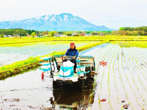 a woman riding a tractor in a field at Appi Life is Beautiful in Hachimantai