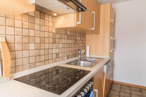 a kitchen with wooden cabinets and a sink at Haus Irene mit Terrasse in Salem
