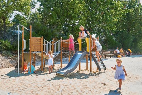 un groupe d'enfants jouant sur une aire de jeux dans l'établissement Domaine de Lanzac, à Lanzac