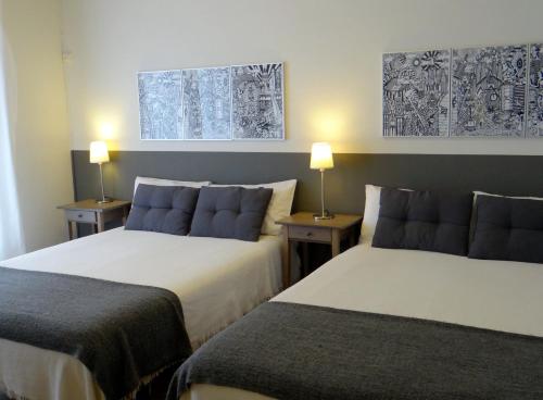 バルセロナにあるオスタル エル ニノートのベッド2台 ホテルルーム ランプ2つ付