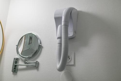 a hair dryer on a wall next to a mirror at WS Tour Eiffel - Nicolo in Paris