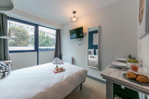 a bedroom with a white bed and a table with food on it at WS Tour Eiffel - Nicolo in Paris