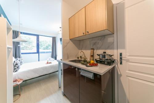 a kitchen with a sink and a bed in a room at WS Tour Eiffel - Nicolo in Paris