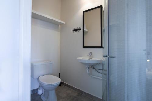 La salle de bains est pourvue de toilettes, d'un lavabo et d'un miroir. dans l'établissement Lindvig - Ferie i naturen, à Nymindegab