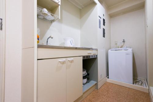 a white kitchen with a sink and a refrigerator at Kyoto Yoshii House in Kyoto