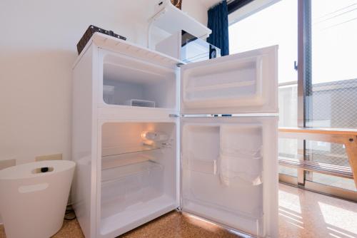 frigorifero bianco con porta aperta in una stanza di Kyoto Yoshii House a Kyoto