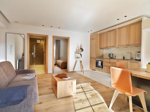 cocina y sala de estar con sofá y mesa en Riedz Apartments Innsbruck- Zentrales Apartmenthaus mit grüner Oase en Innsbruck