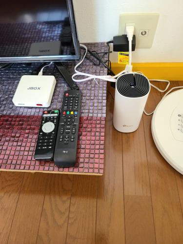 a desk with a laptop computer and a remote control at Bluebird Hotel in Fujikawaguchiko
