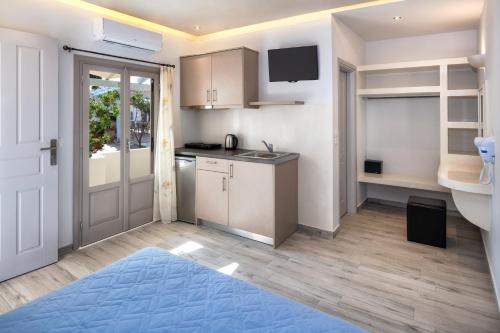 a kitchen with white cabinets and a blue rug at Villa Eleftheria in Perivolos