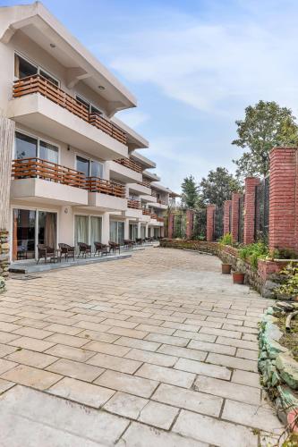 a large building with a patio in front of it at Club Mahindra Kanatal in Kanatal