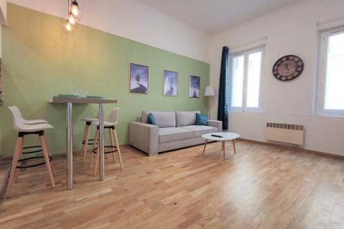 un salon avec un canapé, une table et des chaises dans l'établissement Joli T2 proche Vieux-port, Terrasses du port et Metro Joliette, à Marseille