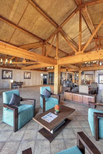 a large living room with couches and a table at Club Mahindra Kanatal in Kanatal