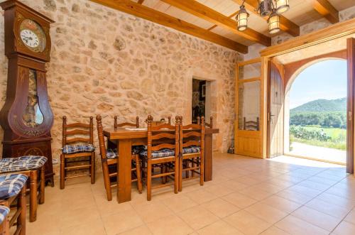 a dining room with a table and a clock at Can Gallot De Punxuat in Algaida