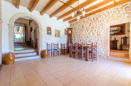 a room with a stone wall and a table and chairs at Can Gallot De Punxuat in Algaida