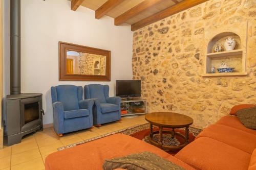 a living room with a couch and chairs and a fireplace at Can Gallot De Punxuat in Algaida
