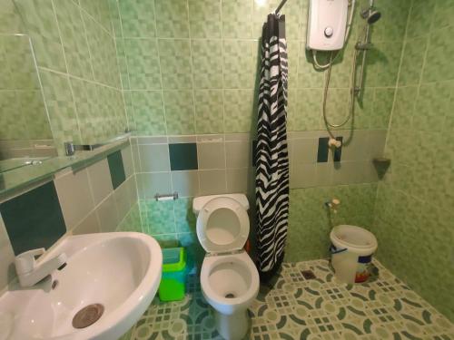 a bathroom with a sink and a toilet and a shower at Moalboal T Breeze Coastal Resort in Moalboal
