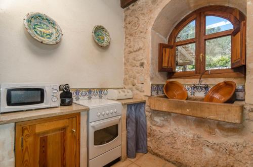 a kitchen with a stove and a microwave at Can Gallot De Punxuat in Algaida