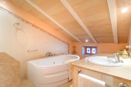 a bathroom with a tub and a sink at Can Gallot De Punxuat in Algaida