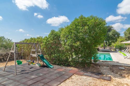a playground with a swing and a pool at Can Gallot De Punxuat in Algaida