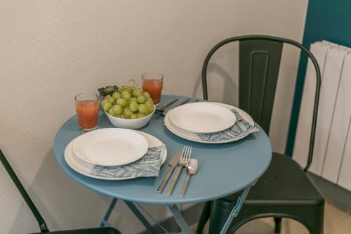 a blue table with plates and a bowl of grapes at WS Tour Eiffel - Nicolo in Paris
