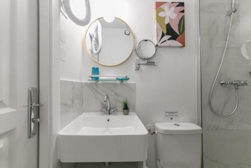 a bathroom with a sink and a toilet and a mirror at WS Tour Eiffel - Nicolo in Paris