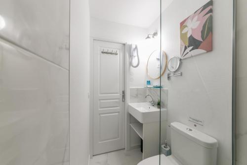 a white bathroom with a toilet and a sink at WS Tour Eiffel - Nicolo in Paris