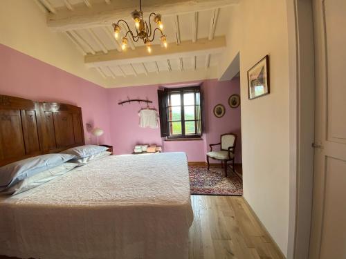 um quarto com paredes cor-de-rosa e uma cama grande em Podere Terreno alla via della volpaia em Radda in Chianti
